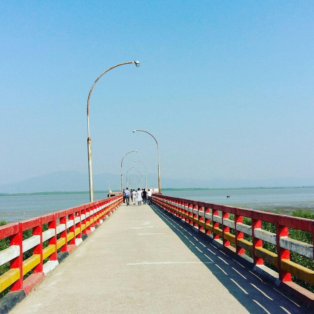 gray concrete pathway near sea during daytime